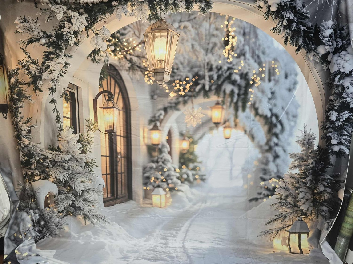 Rustic Christmas scene with decorated trees, wreaths, and vintage barn doors.