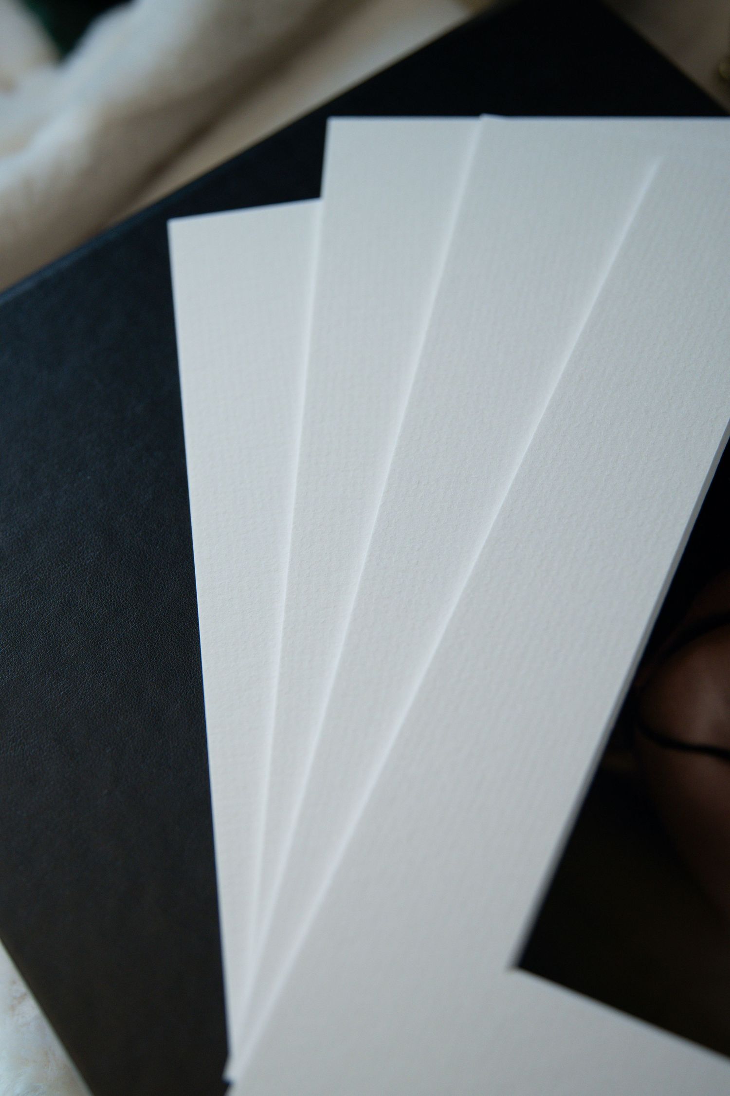 Close-up view of fanned out white paper sheets against a dark background showing texture and contrast.