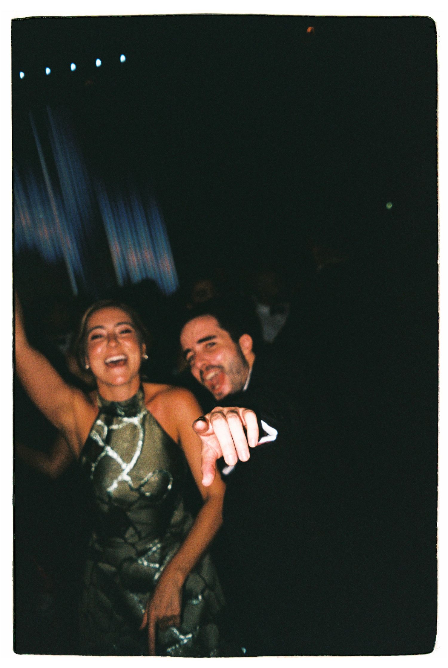 Party scene with people dancing and celebrating in dark nightclub setting.