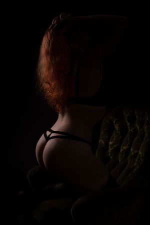 Moody boudoir photography with warm tones and dramatic shadows.