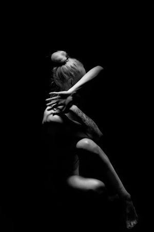 Monochrome study of graceful body movements in dark contrast lighting.
