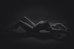 Minimalist black and white landscape of reclining silhouettes.