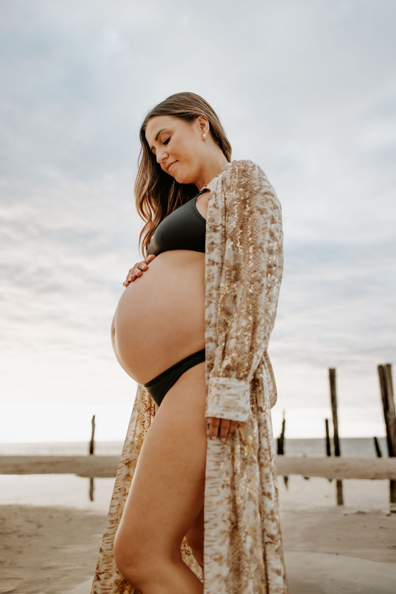 Expectant mother at the jetty ruins during a natural sunset pregnancy photography session at Port Willunga, South Australia