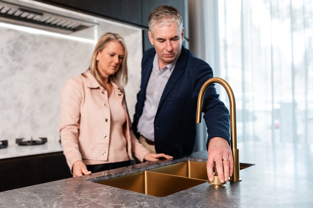 Contemporary kitchen design showcasing marble surfaces and brass fixtures.