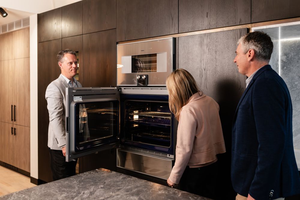Luxurious kitchen display featuring dark wood panels and integrated appliances.