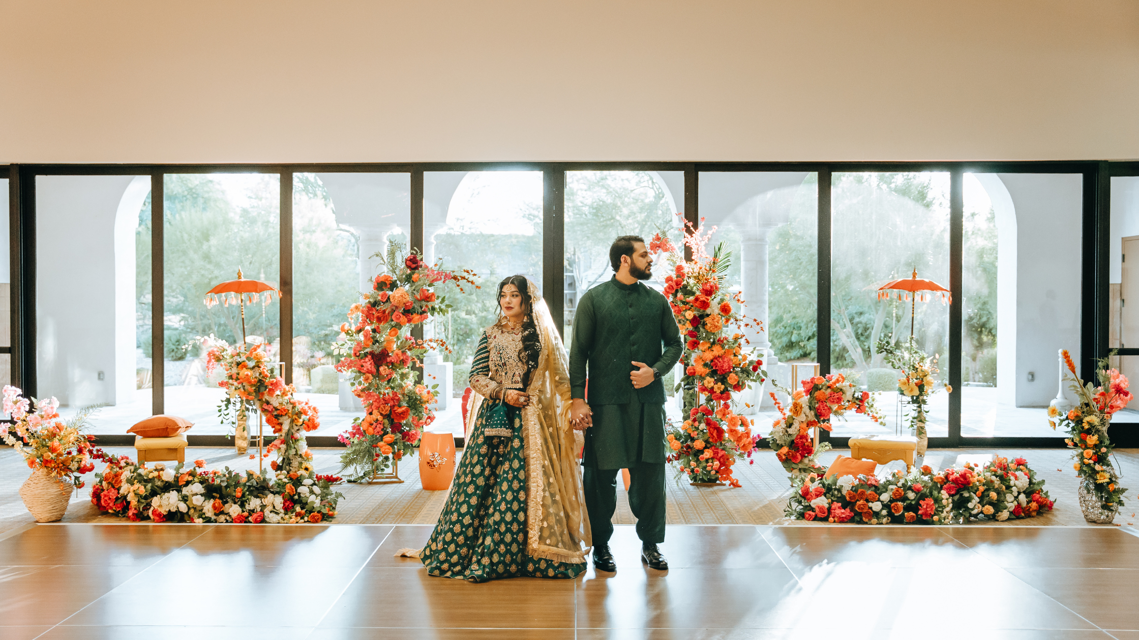 Interior space with autumn-themed decor and large windows displaying orange floral arrangements.