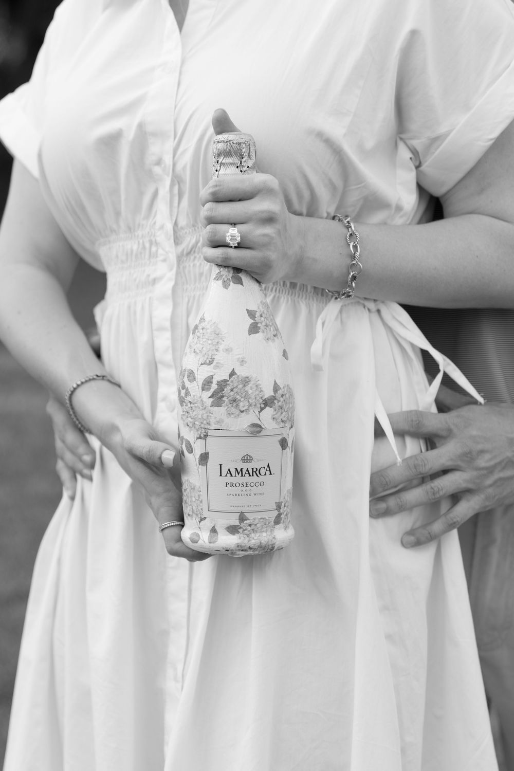 Bride-to-be surprised at Cherokee Cottage proposal with personalized prosecco and blue hydrangea label, Jekyll Island.