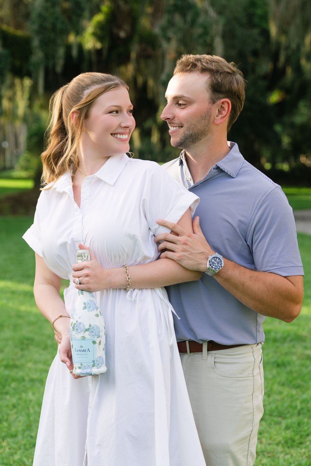 Bride-to-be surprised at Cherokee Cottage proposal with personalized prosecco and blue hydrangea label, Jekyll Island.