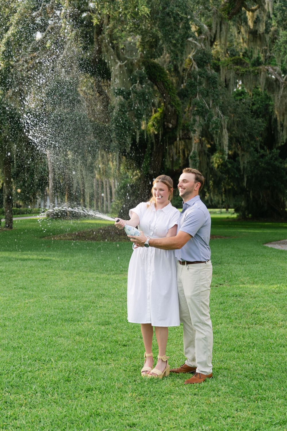 Couple toasting champagne after proposal near Cherokee Cottage, Jekyll Island, Georgia—Golden Isles engagement photography.