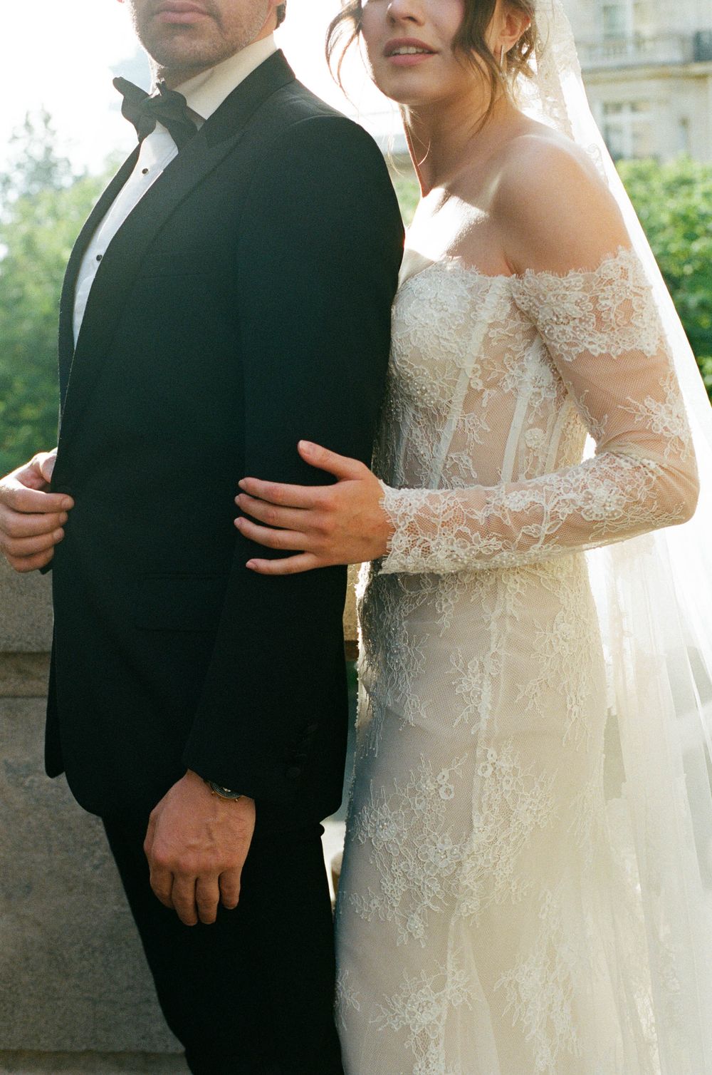 A close-up series of wedding photos showing cropped formal attire with a black tuxedo and white lace gown details.