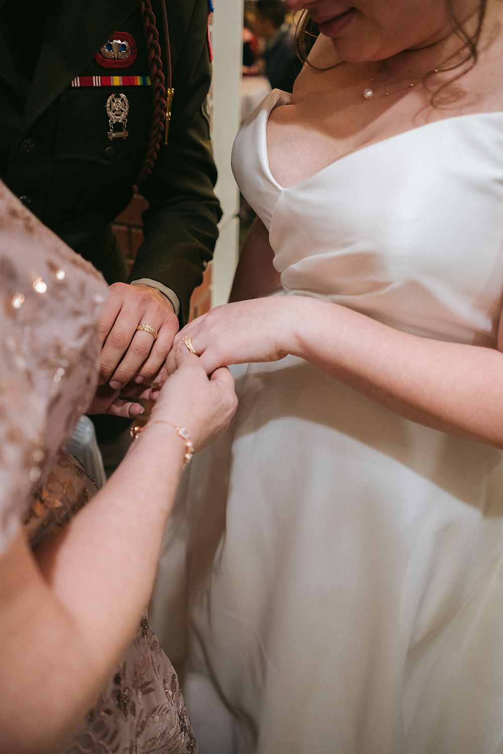 Close-up shot of hands exchanging rings during an intimate wedding ceremony moment.