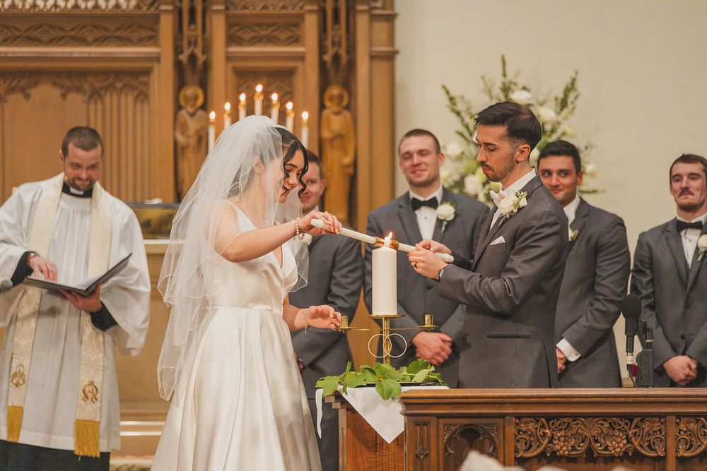 A wedding ceremony in progress inside a traditional church with wooden decor.