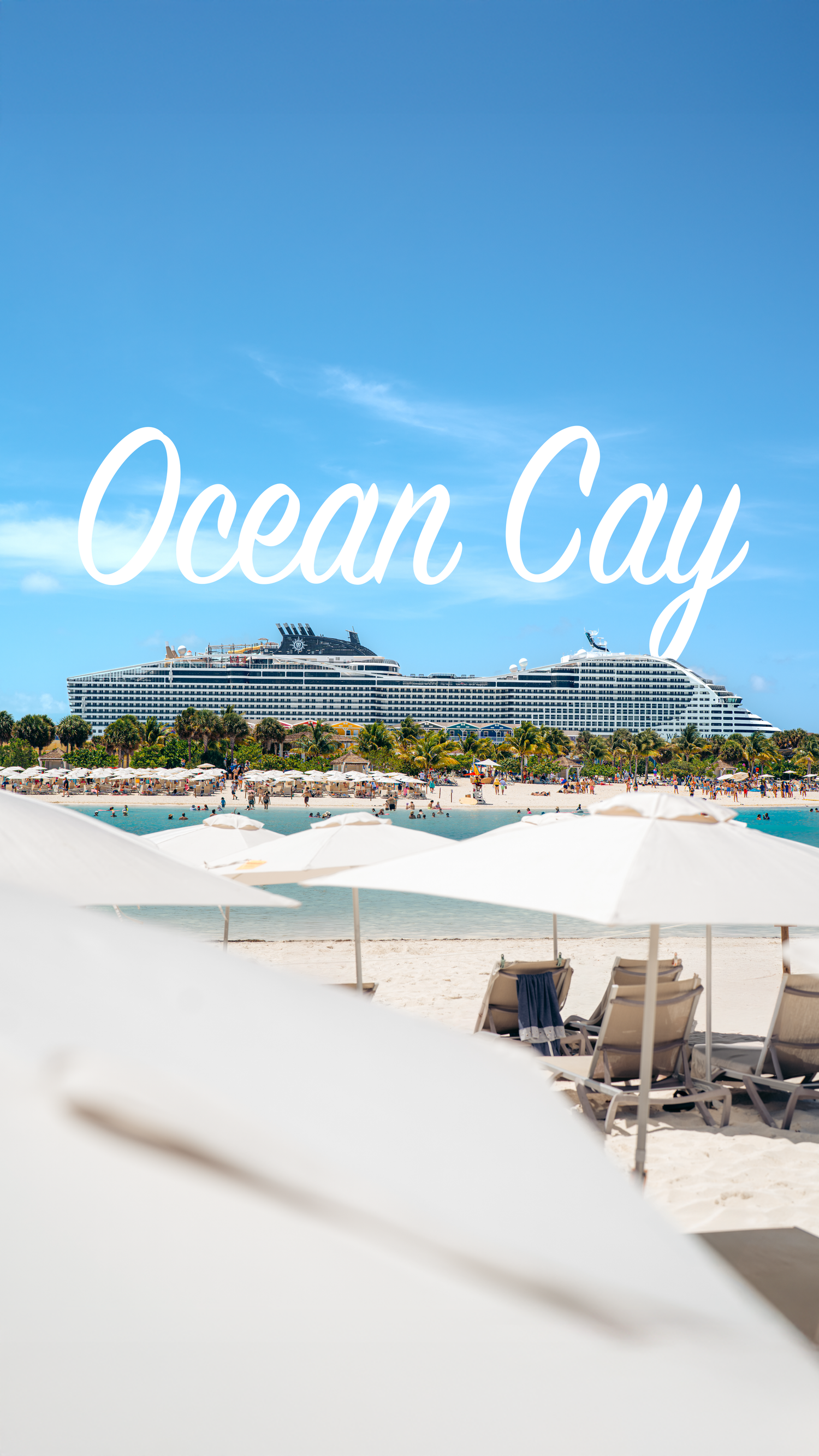 Modern cruise ship and beach lounge chairs at a tropical resort destination under bright blue skies.