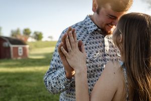 Romantic couple sharing tender moments in a sunlit field.