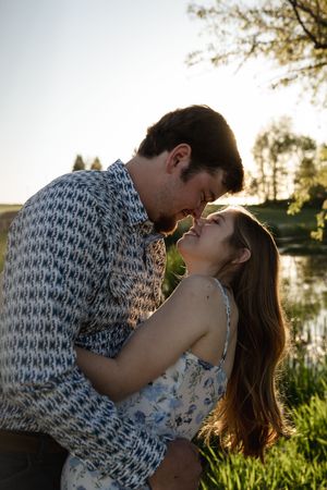 Romantic sunset photoshoot with couple in floral dress and patterned shirt.