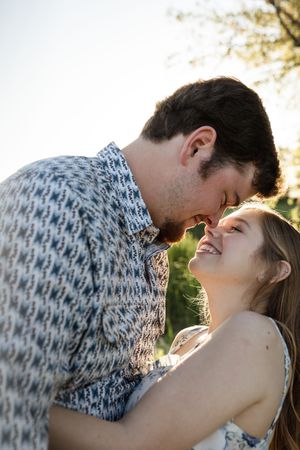 Intimate couple sharing a tender moment in golden sunlight outdoors.