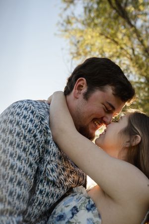 Close-up of romantic couple sharing tender moment in golden sunlight.