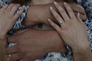 Intimate black and white photo of hands during a proposal.