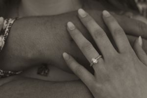 Black and white image of hands during a romantic proposal moment.