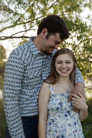 Sweet candid moments captured between a couple during their engagement session in a park setting.
