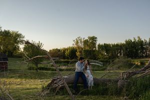 A panoramic view of a rural landscape at sunset with figures visible in the distance.