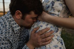 Intimate moment captured between couple in countryside setting.