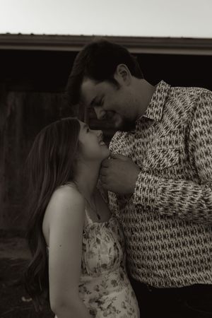 Romantic black and white portrait against rustic wooden backdrop.