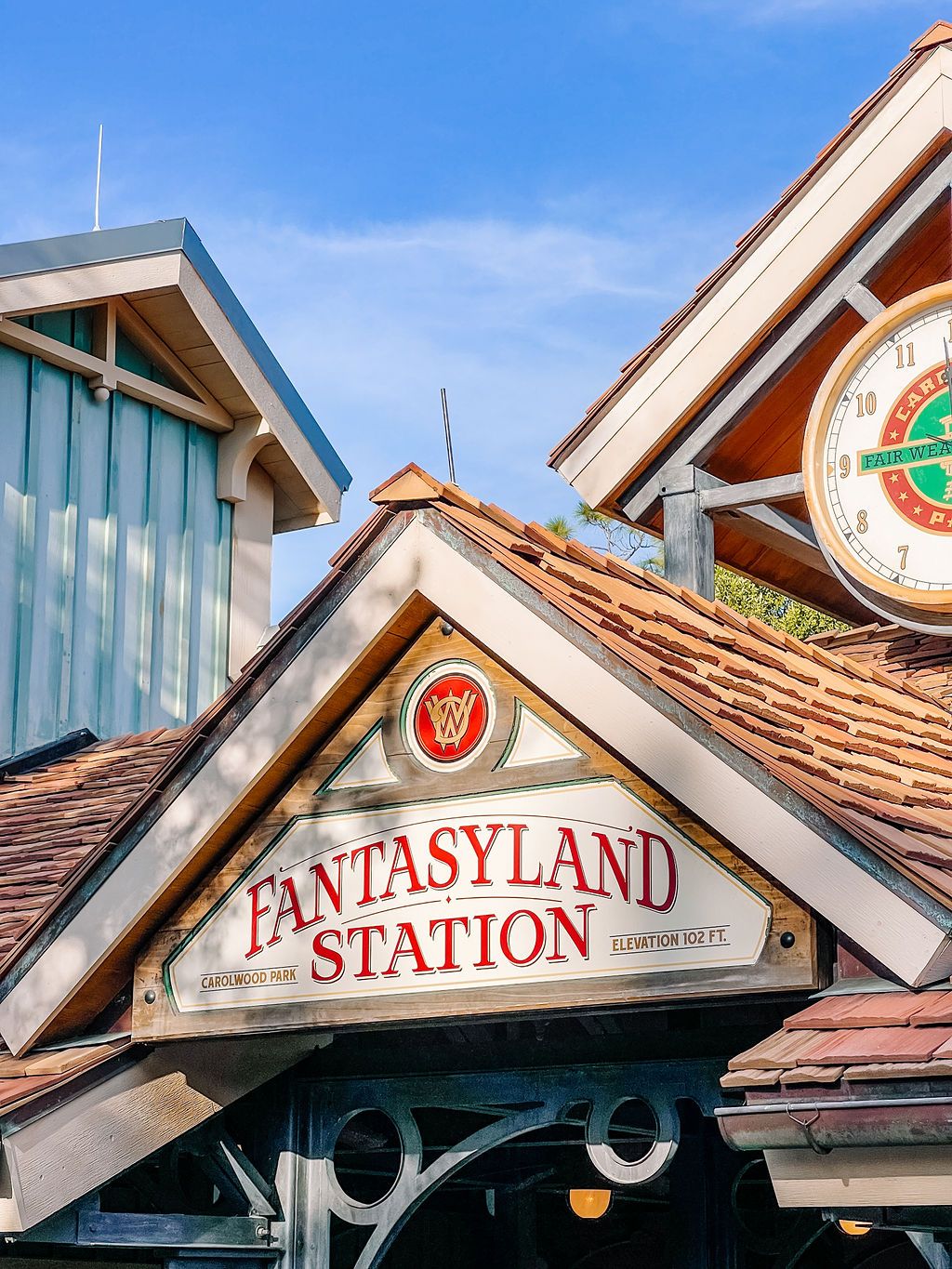 Three connected photos showing architectural details of the Fantasyland Station sign and roofline at Disney theme park.