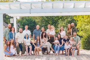 A group of people sitting together outdoors on white steps for a casual photo session.
