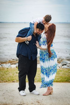 A romantic couple shares tender moments by the ocean shore in a series of intimate photographs.
