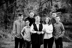 Black and white collage of outdoor family portraits showing six different poses in a natural setting.