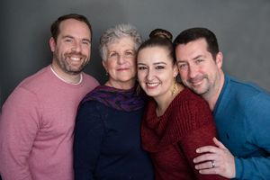 A series of candid family portraits showing people in casual clothing embracing and smiling together against neutral backgrounds.