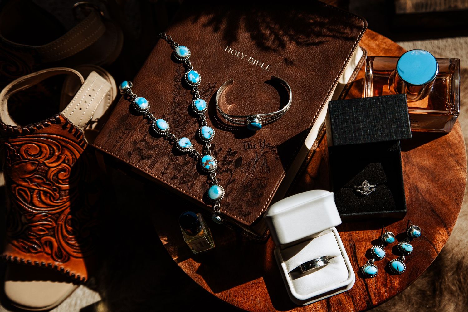 Turquoise beaded jewelry and western accessories arranged on a rustic wooden surface with vintage styling.