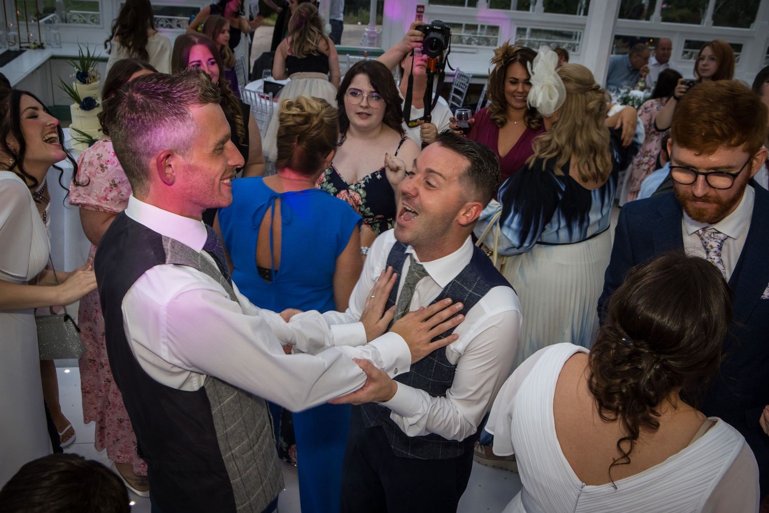 Energetic dancing and celebration at indoor wedding reception.