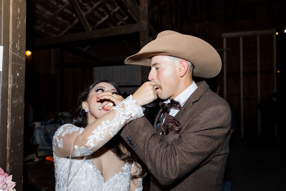 A joyful wedding reception moment featuring a cowboy hat and laughter.