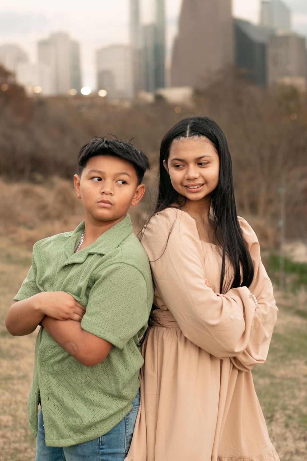 Portrait of two young people with Houston skyline visible in background.