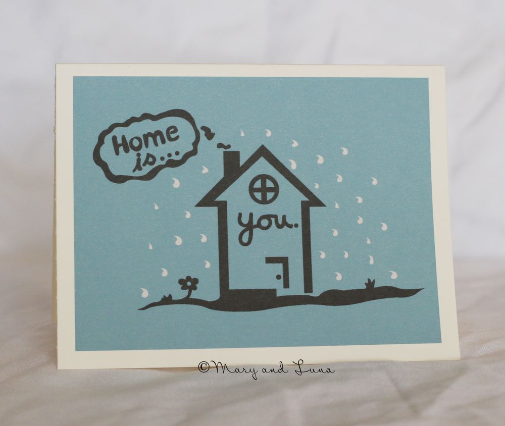 greeting card with digital art of a house in the rain. text says "home is you"