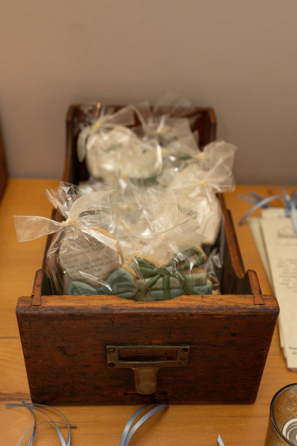 Vintage wooden drawer filled with wrapped party favors in light blue and white.