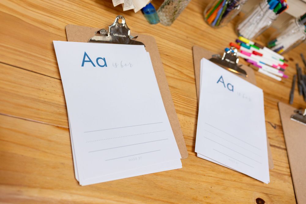 White place cards or name cards arranged on a wooden floor.