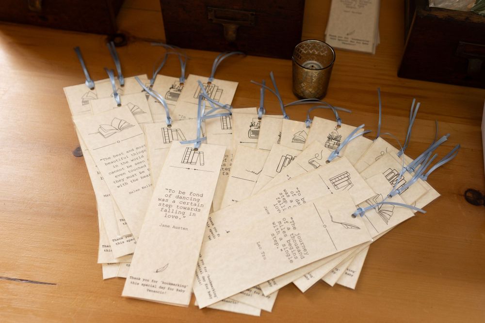 Collection of handwritten cards or tags with blue ribbons spread across wooden surface.