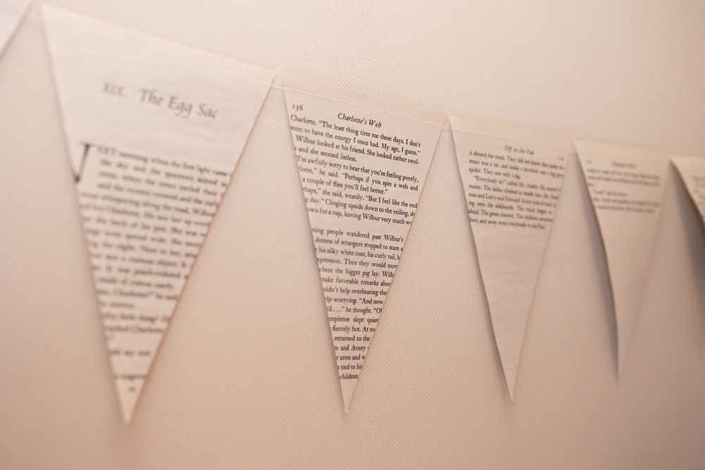 White paper bunting with text hanging against a neutral wall.