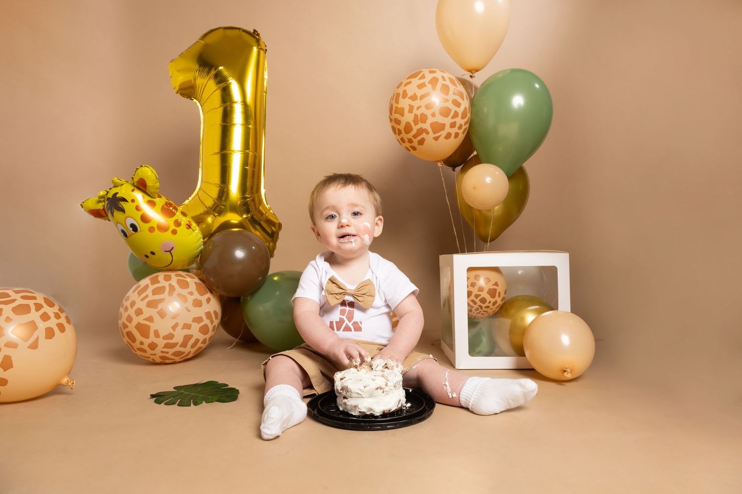 A baby's first birthday setup with gold number one balloon and pastel decorations.