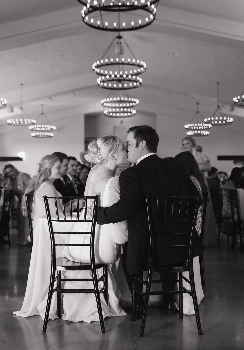 A romantic black and white photo sequence shows a couple in formal attire sharing an intimate moment at a reception venue.