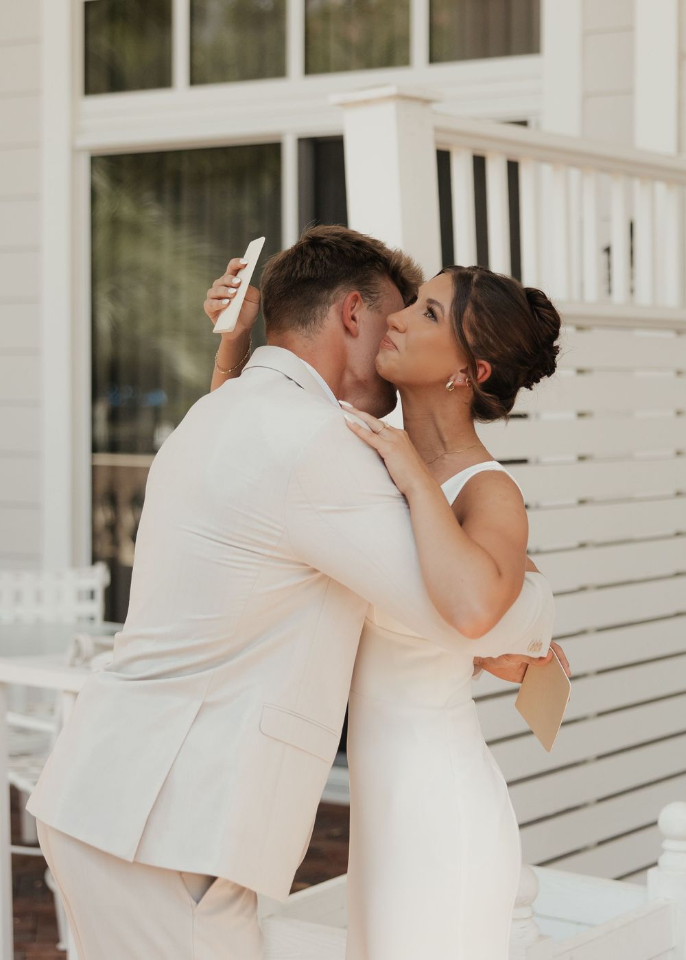 A couple in white wedding attire share a romantic kiss sequence against a white porch background.