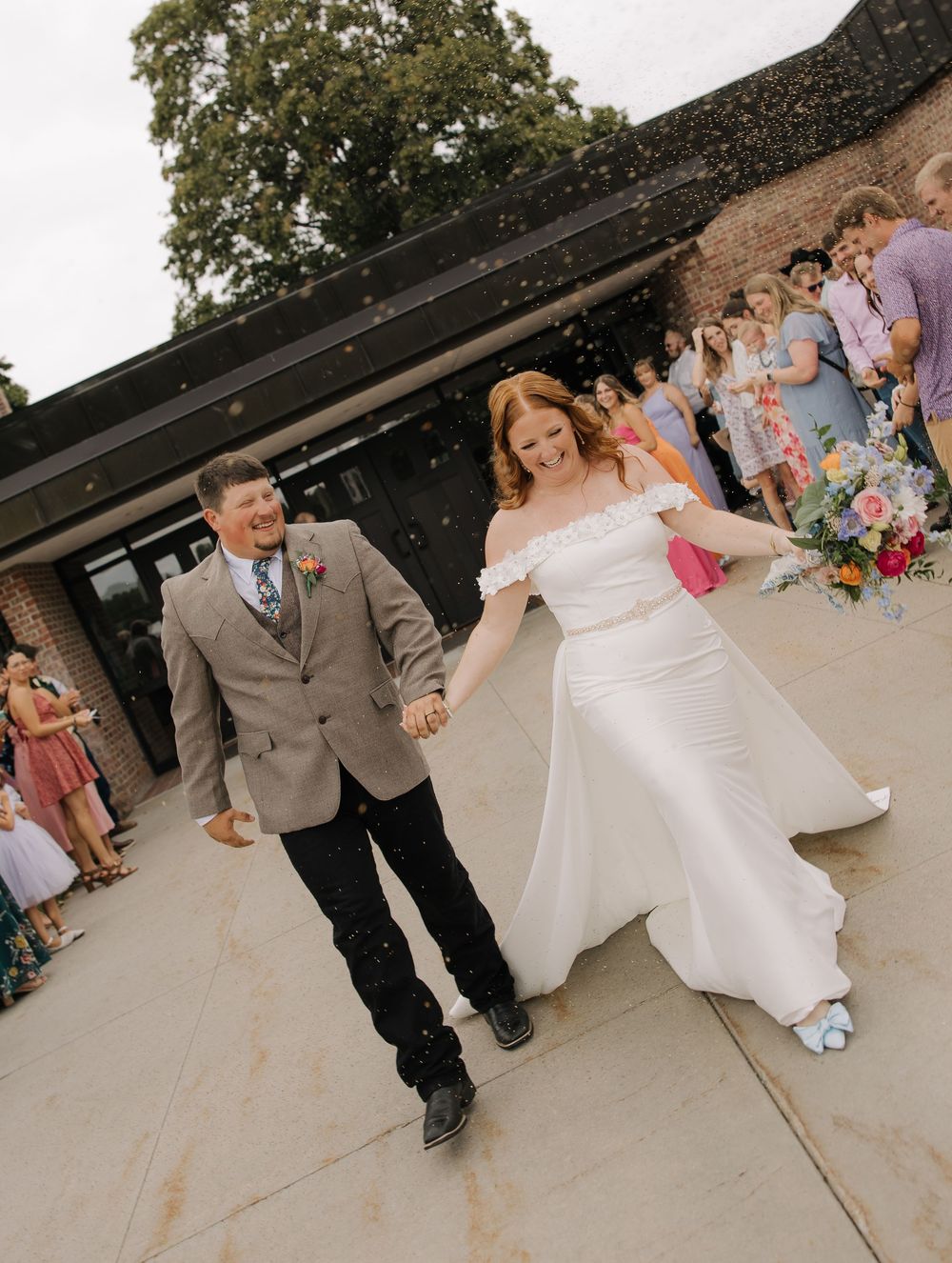 Wedding couple performs traditional first dance dip move on outdoor dance floor during reception celebration.