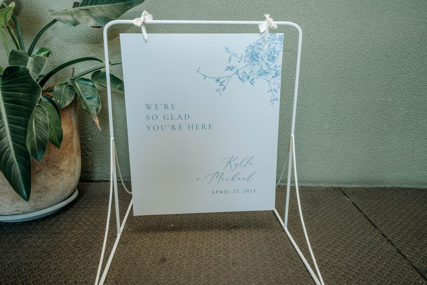 Wedding welcome sign in white frame stand with blue floral design.