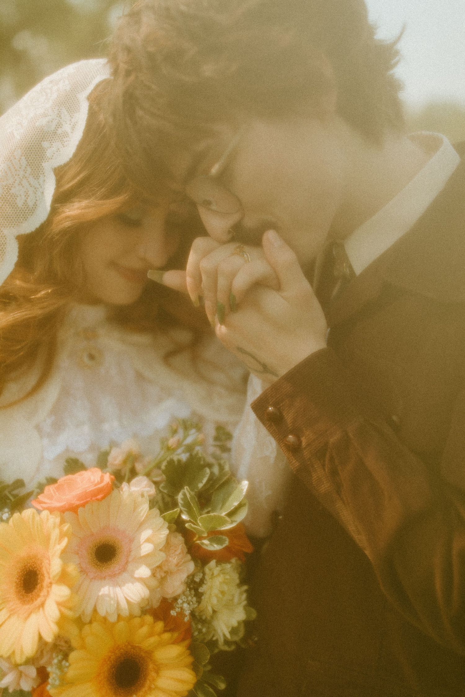 Romantic vintage-style wedding photo with peach gerbera daisy bouquet in golden sunlight.