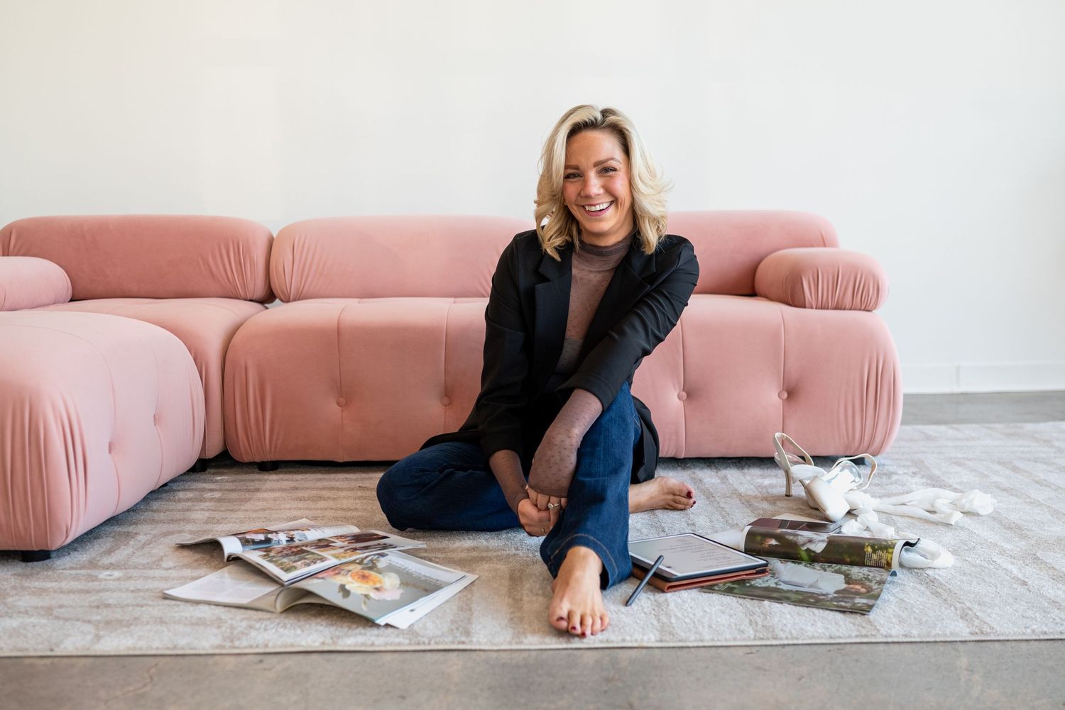 Casual lifestyle photo on pink sectional sofa with magazines spread on floor.