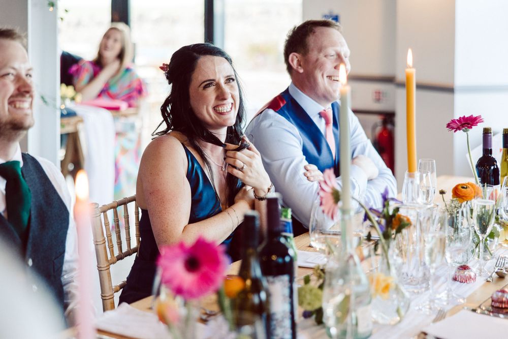 Elegant wedding reception with pink floral centerpieces and candlelit table settings.