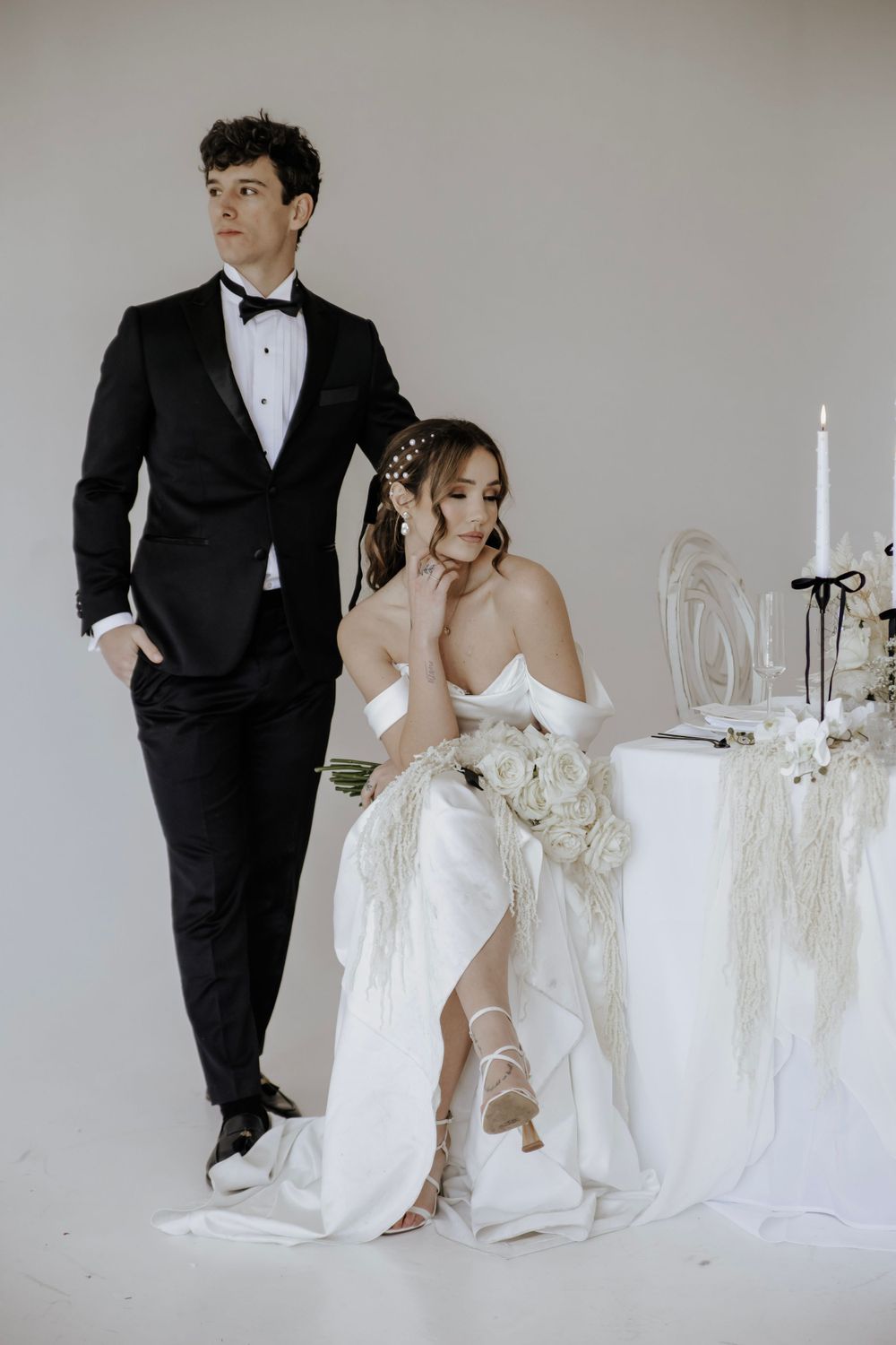 Groom poses behind bride at table